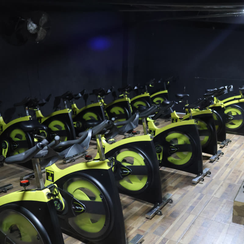 Salón de spinning con bicicletas sobre piso de madera
